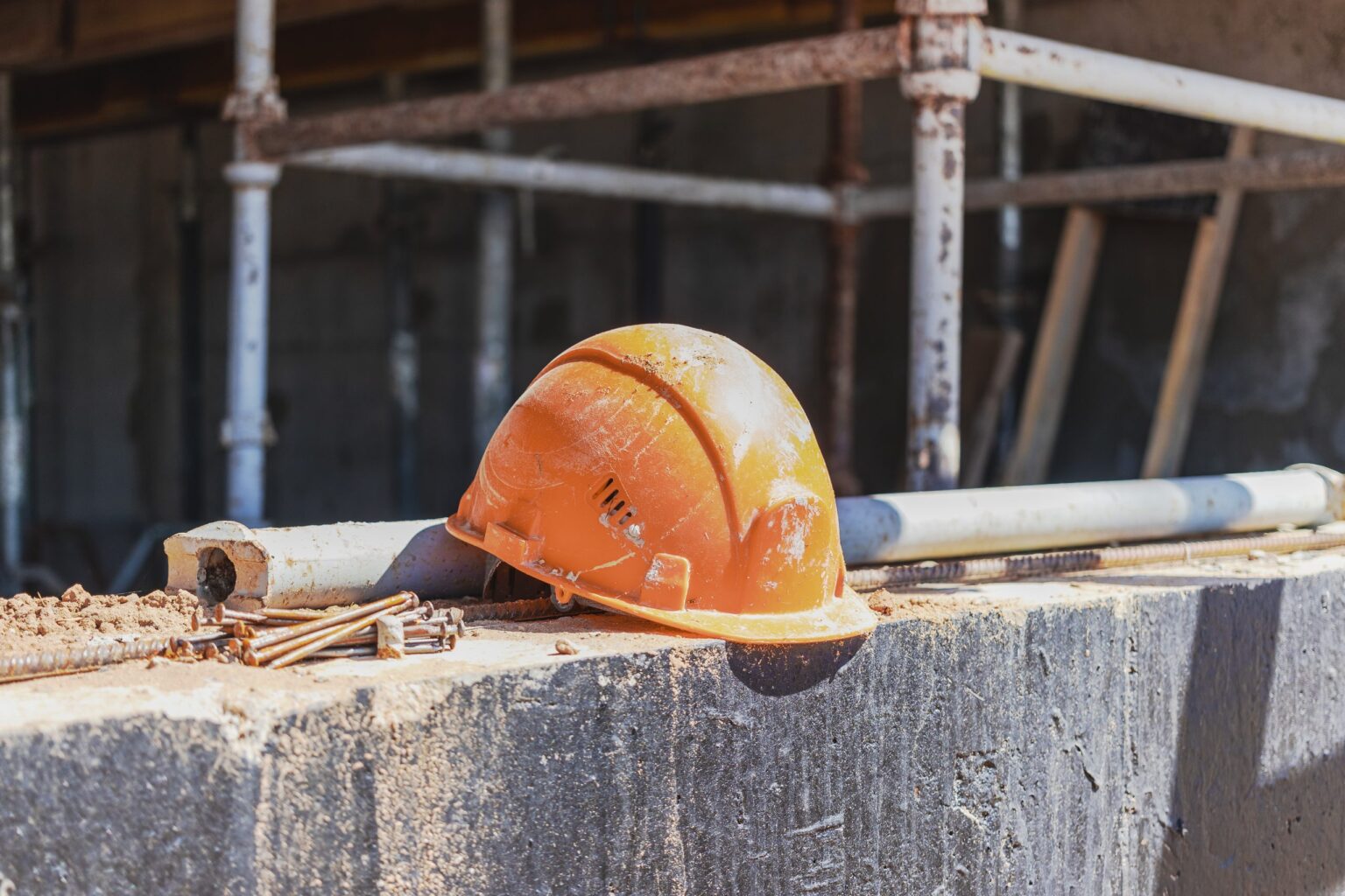 Casque de chantier posé sur une fondation en béton, assurance construction BTP